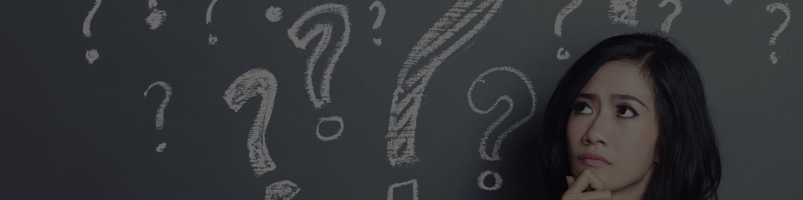 Woman thinking in front of a blackboard